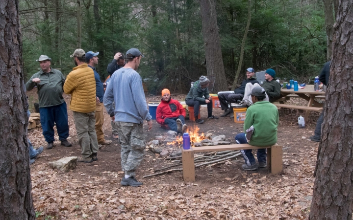 a group of veterans sit around a fire on an outward bound veterans expedition 